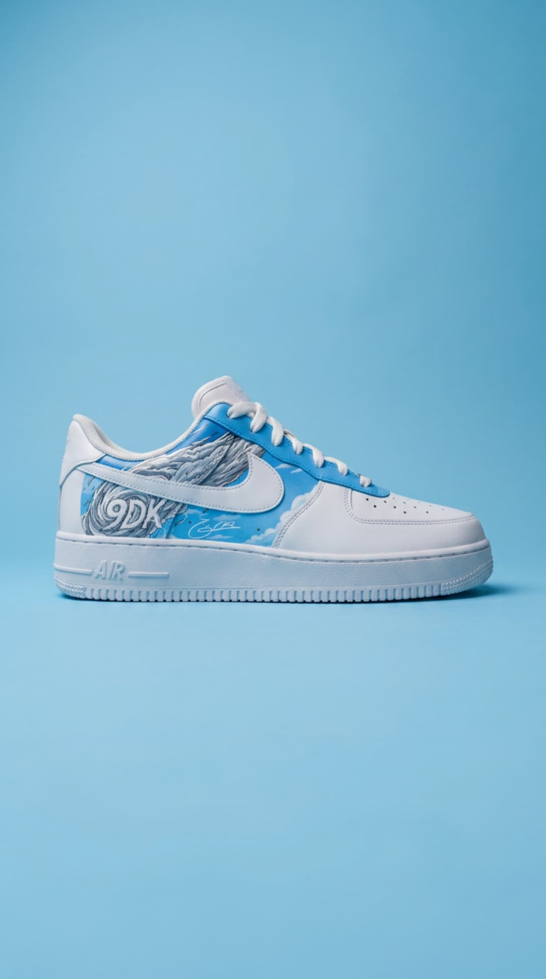 White Air Force 1 with a 9DK cloud panel against a sky-blue studio backdrop