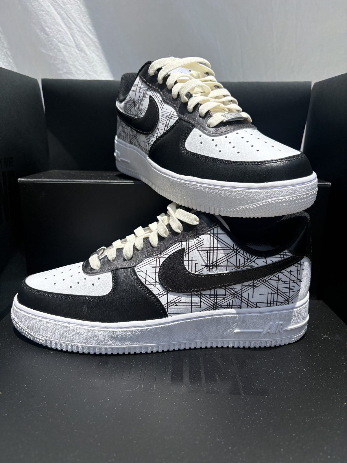 Pair of black and white Air Force 1s with a hand-drawn sketch line print and cream laces