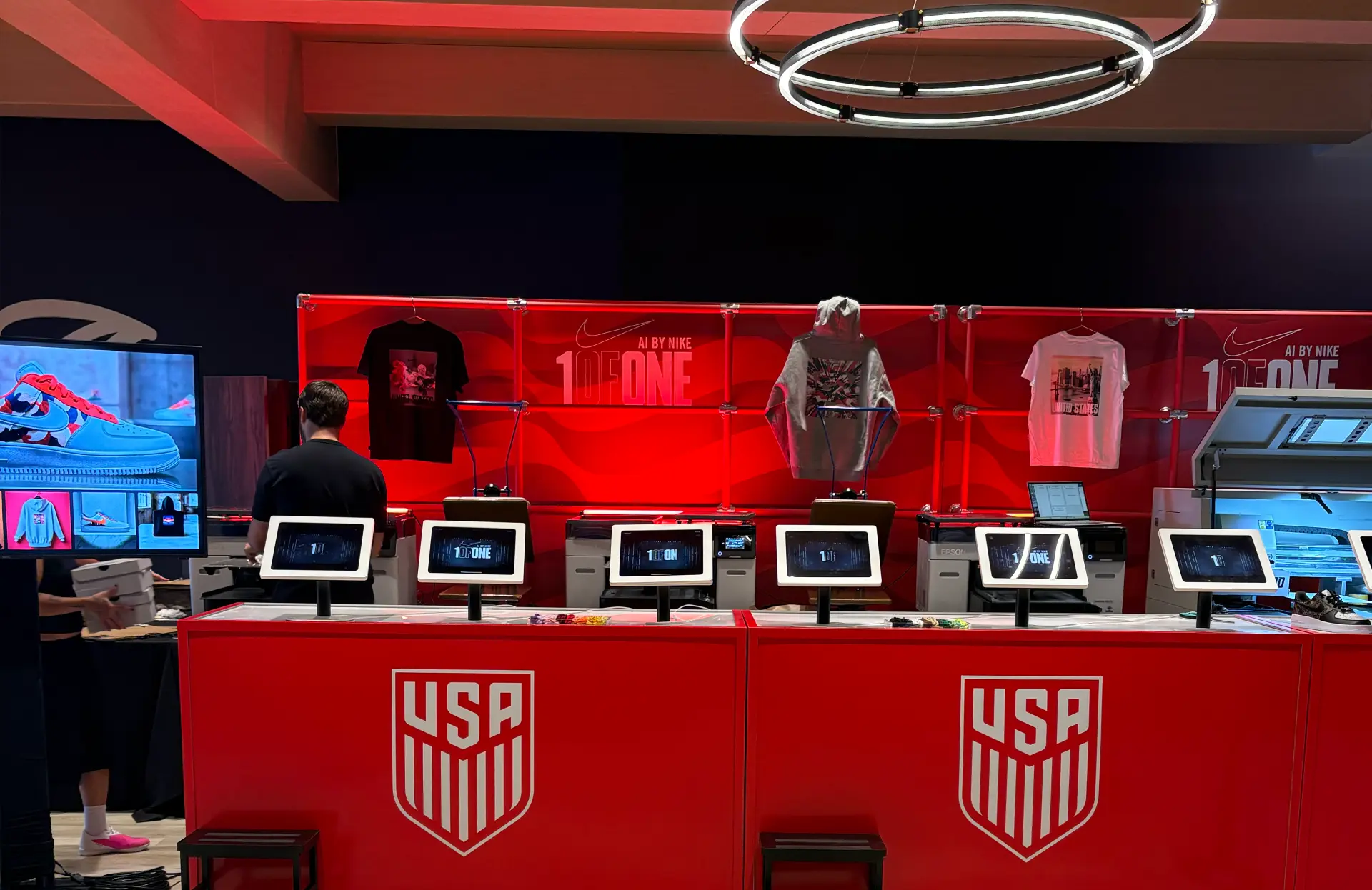 United States 1ofONE booth with tablets, apparel and printers