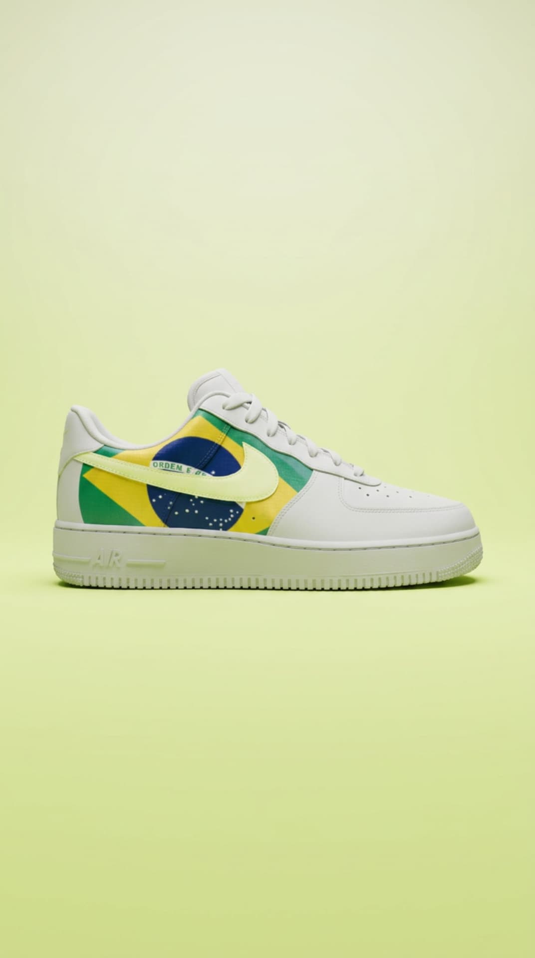 White Air Force 1 with a Brazil flag panel and volt swoosh against a lime studio backdrop