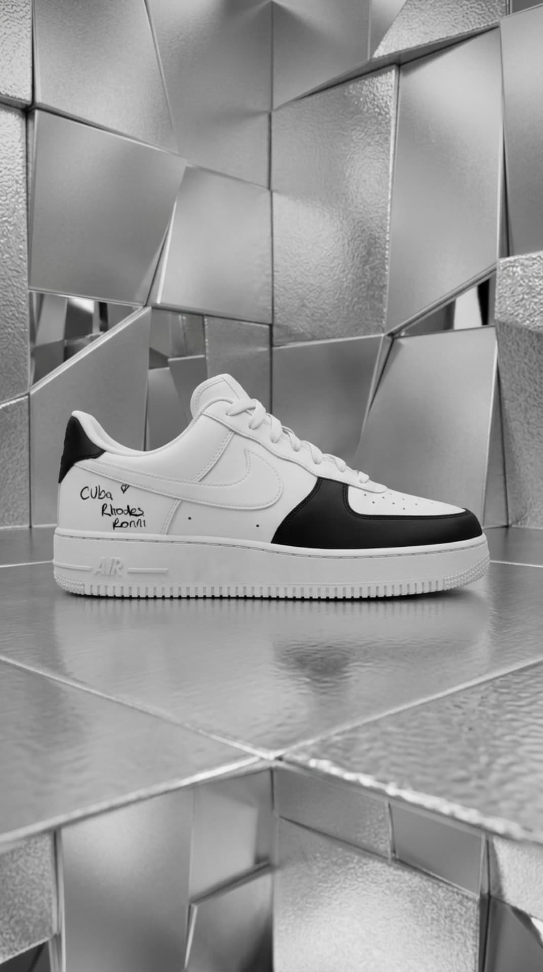 White and black Air Force 1 with handwritten family names on the heel, displayed in a faceted silver mirror room