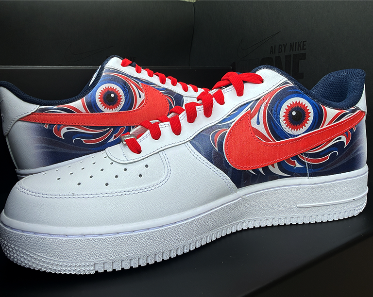 Pair of white Air Force 1s with red swooshes and blue and red eye graphics on the side panels