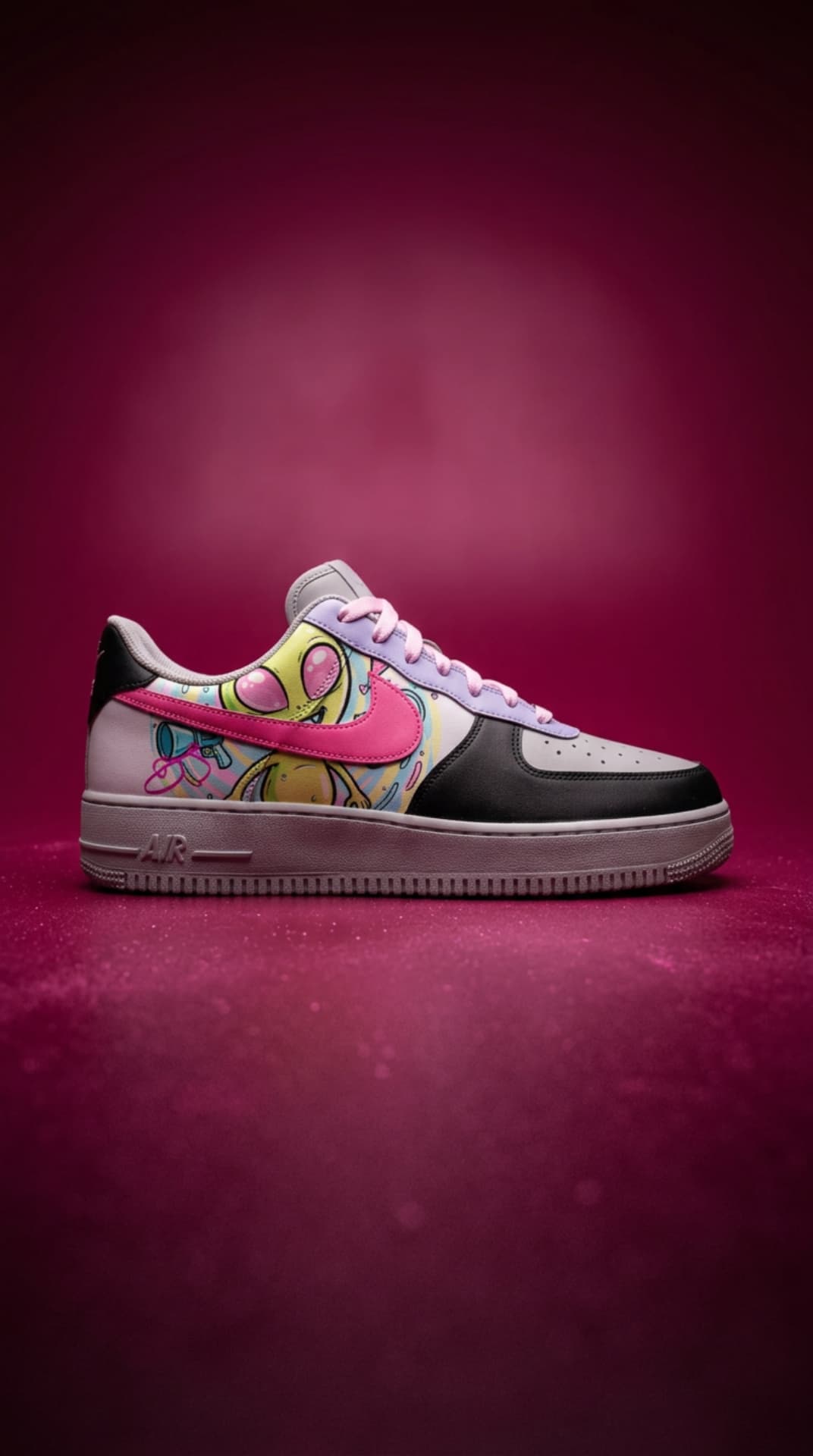 Pastel Air Force 1 with a cartoon alien graphic panel and pink swoosh against a magenta studio backdrop